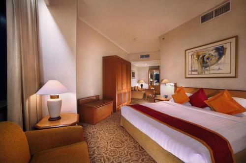 雅加达梅纳拉半岛酒店的酒店客房带一张大床和一把椅子