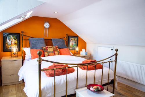海斯廷斯Seagulls Nest Beachfront Apartment With 3 Bedrooms的一间卧室配有一张橙色墙壁的床