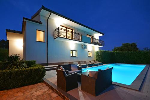 特里尔Villa Bisko with heated pool & jacuzzi的夜间带游泳池的别墅