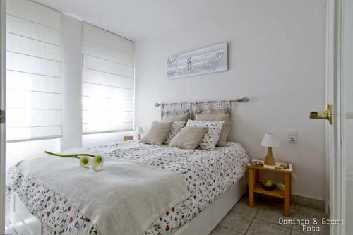 卡拉费尔MARICEL Apartment En la playa的白色的卧室设有床和窗户
