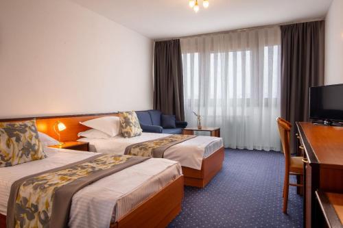 萨格勒布Hotel Novi Zagreb的酒店客房设有两张床和电视。