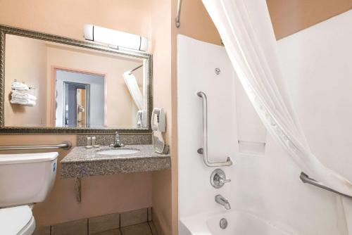 圣安东尼奥圣安东尼奥速8酒店的一间带卫生间、水槽和镜子的浴室