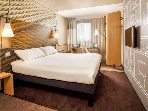 伦敦宜必思伦敦坎宁镇酒店的酒店客房设有一张大床和一台电视。