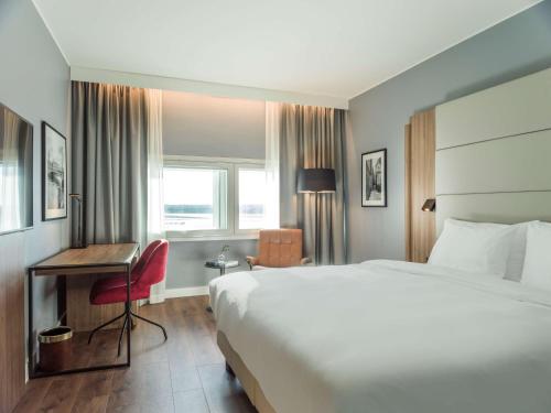 阿兰达Radisson Blu Airport Terminal Hotel的酒店客房设有一张大床和一张书桌。
