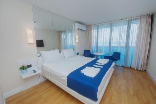 巴统Sea Side orbi city的酒店客房带一张大床以及一张桌子和椅子。
