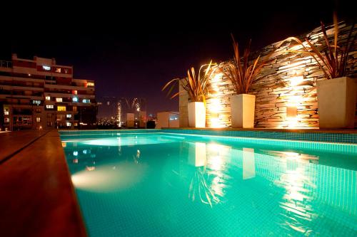布宜诺斯艾利斯洛赛德尔套房公寓的夜间大型游泳池,灯光照亮