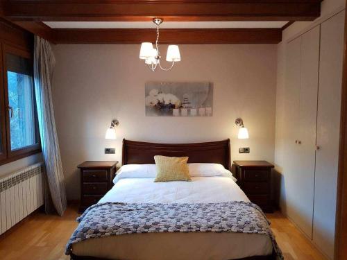 圣胡利娅-德洛里亚Apartamento Chalet en Casa Rural Camp de Claror的一间卧室配有一张带2个床头柜的大床