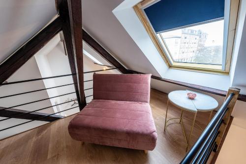 圣康坦Le Magnifique Appart'Hotel Le Gatsby的客厅配有红色椅子和桌子