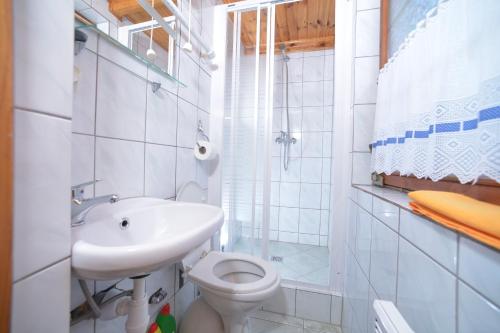 德兹维济诺Domki Pod Wydmami 40m od plaży的白色的浴室设有水槽和卫生间。