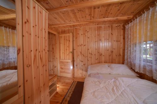 德兹维济诺Domki Pod Wydmami 40m od plaży的小木屋内一间卧室,配有两张床