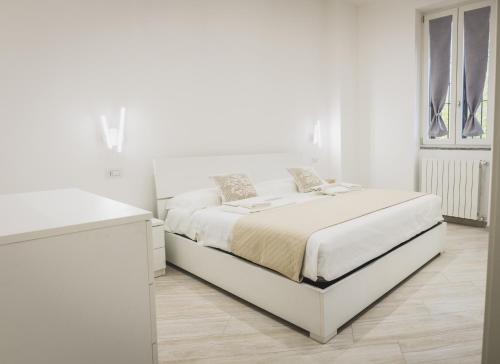 米兰Residenze Niguarda的白色的卧室设有白色的床和窗户。