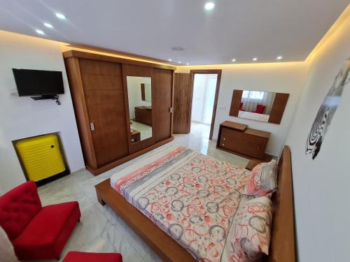 拉马萨Tonny House的一间卧室配有一张大床和一张红色椅子
