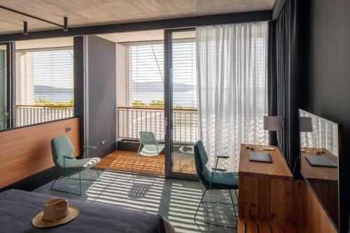 扎通Hotel Osmolis的一间带一张床和一张书桌的卧室以及一个阳台