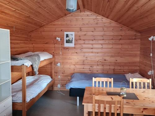 HedeSonfjällscampen的客房设有两张双层床和一张桌子。