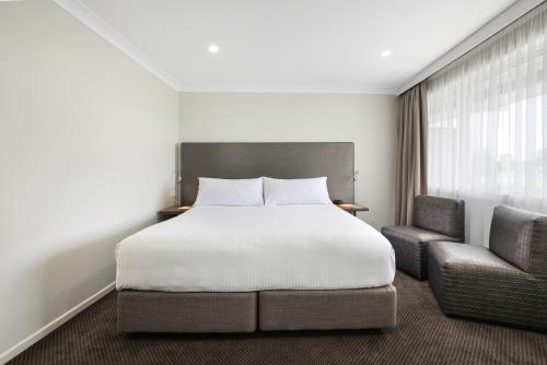 塔姆沃思鸭子宾馆公寓的一间卧室配有一张床和两把椅子
