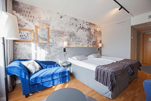 库奥皮奥斯堪库奥皮奥酒店的一间卧室配有一张大床和一张蓝色椅子