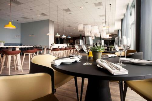 克里斯蒂安桑克里斯蒂安桑比斯特兰达斯堪迪克酒店的用餐室配有桌椅和酒杯