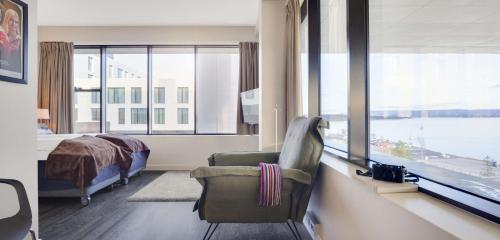福尼布斯堪福尼布酒店的一间卧室配有一张床、一把椅子和一个大窗户
