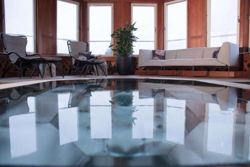 布罗斯布罗斯斯堪迪克广场酒店的客厅设有游泳池、椅子和沙发