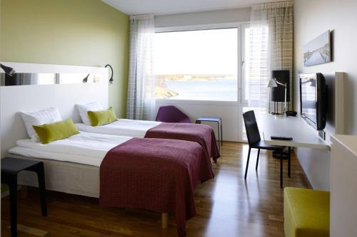卡尔斯克鲁纳斯堪迪克卡尔斯克鲁纳酒店的酒店客房设有两张床、一张书桌和一个窗户。