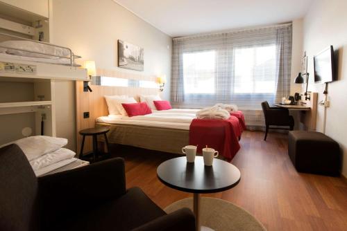 松兹瓦尔松兹瓦尔斯堪迪克酒店的一间卧室配有一张床、一张沙发和一张桌子
