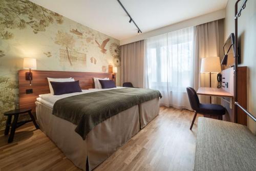 韦斯特罗斯瓦斯特拉斯堪迪克酒店的酒店客房设有一张大床和一张书桌。