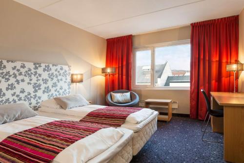 希尔科内斯希尔科内斯斯堪迪克酒店的酒店客房设有两张床、一张书桌和一个窗户。