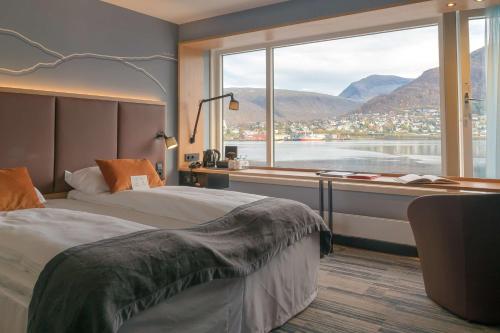 特罗姆瑟斯堪迪克伊萨维斯酒店的酒店客房设有两张床和大窗户。