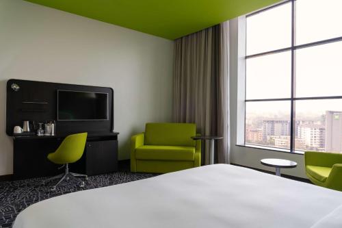 内罗毕内罗毕韦斯特兰德丽柏酒店的酒店客房配有一张床、两把椅子和一台电视