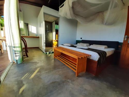 埃拉Minthu Homestay的一间卧室配有一张床和一张木凳