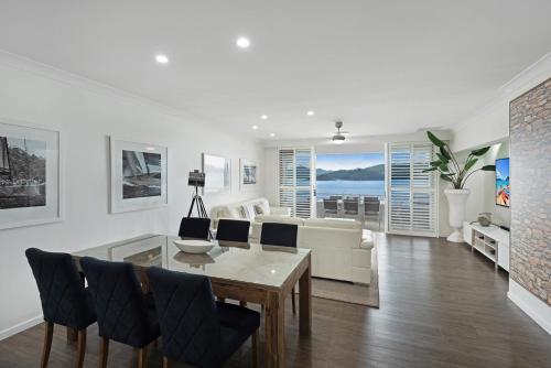 汉密尔顿岛Frangipani Beachfront Lodge 202 on Hamilton Island by HamoRent的客厅配有桌椅和沙发