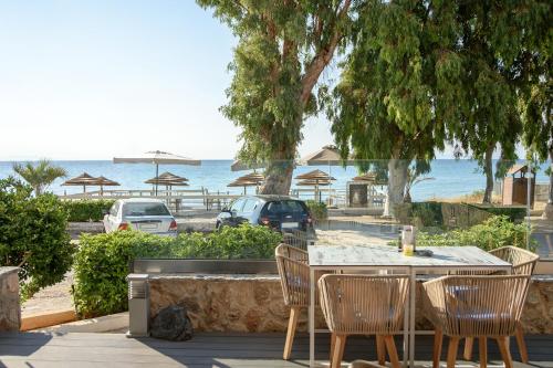 阿特米达Seasabelle Hotel near Athens Airport的一张桌子和椅子,享有海滩美景