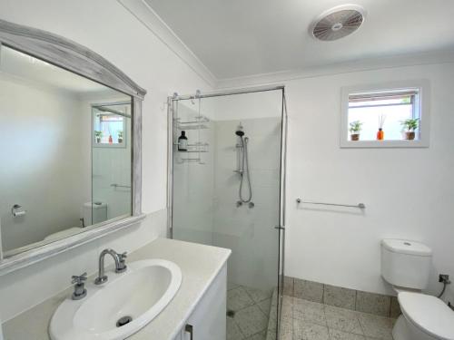 BroadwaterPeppermint Cottage的带淋浴和盥洗盆的白色浴室