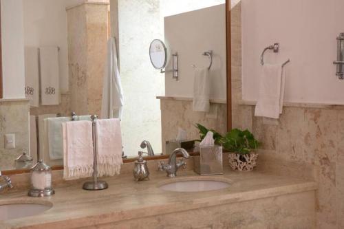 拉罗马纳Chic Luxury Condo At Los Altos Casa De Campo的一间带两个盥洗盆和大镜子的浴室