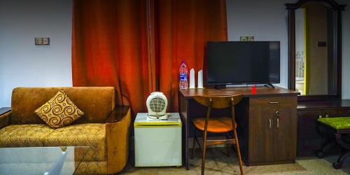 Lakshmanpur BālāpāraEque Heritage Hotel & Resort的客厅配有椅子和电视