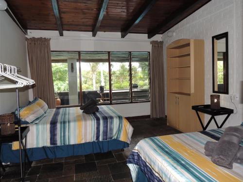 圣卢西亚Bushpigs Haven的一间卧室设有两张床和大窗户