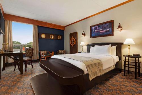 弗雷德里克顿弗雷德里克顿华美达酒店的酒店客房设有一张大床和一张书桌。