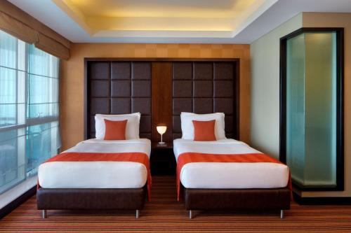 迪拜迪拜媒体城丽笙酒店的配有窗户的酒店客房内的两张床