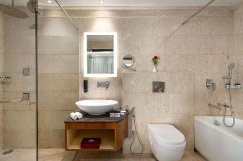 ChandauliRamada by Wyndham Varanasi Katesar的浴室配有盥洗盆、卫生间和浴缸。