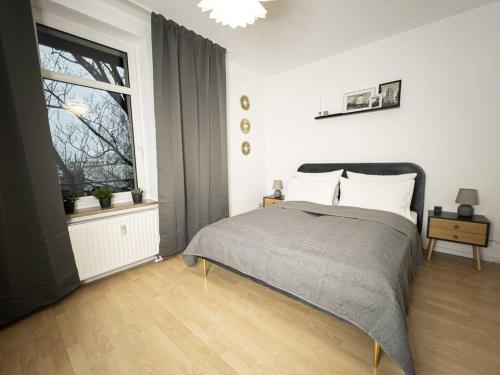 莱比锡Purer Luxus mit 2 Schlafzimmern, Balkon und Privat-Parkplatz的一间卧室设有一张床和一个大窗户
