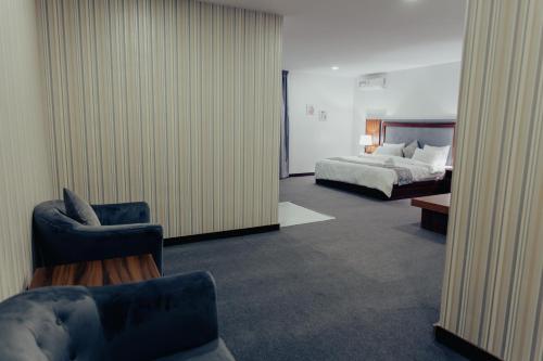 阿布贾Sinclair Lake Chad的酒店客房,配有床、沙发和椅子