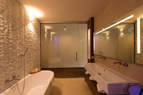 加舒恩Romantik Hotel Verwall的带浴缸、水槽和浴缸的浴室