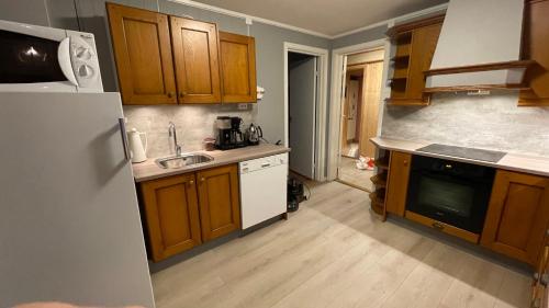RussenesKoselig hus i sentrum av Olderfjord的厨房配有木制橱柜和白色冰箱。