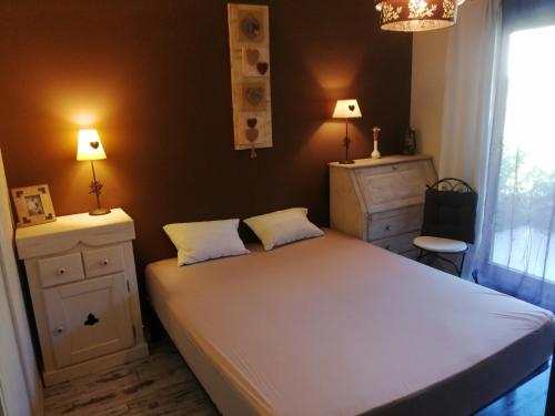 杜萨尔Lac d'Annecy T2 grand jardin的卧室配有一张白色大床和两盏灯。