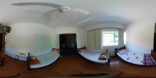 平达莫尼扬加巴Hotel Pousada Liberdade的带三张床和天花板的客房