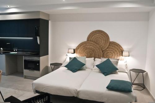 莱斯卡拉Aparthotel El Cargol的卧室配有带绿色枕头的大型白色床
