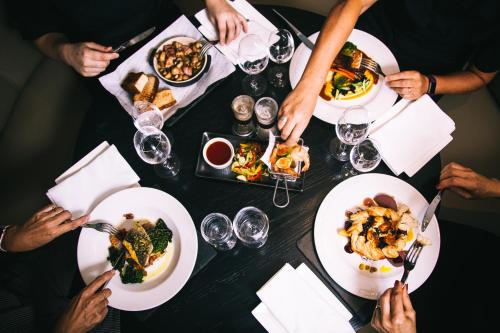 维斯贝希Crown Lodge Hotel的一群坐在桌子旁吃食物的人