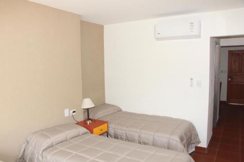 萨尔塔Departamentos Ibazeta的客房设有两张床和一张带台灯的桌子。