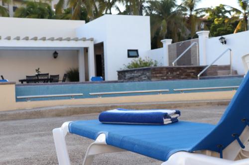 马萨特兰Mar Sol Bungalows & Hotel的游泳池畔的蓝白色沙滩椅