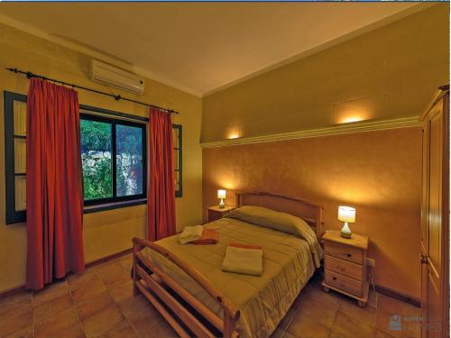 萨奈特Casetta Menzja Semi Detached Bungalow的一间卧室配有床和红色窗帘的窗户